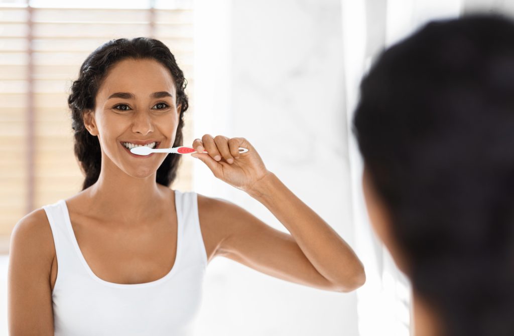 Young woman brushing her teeth.