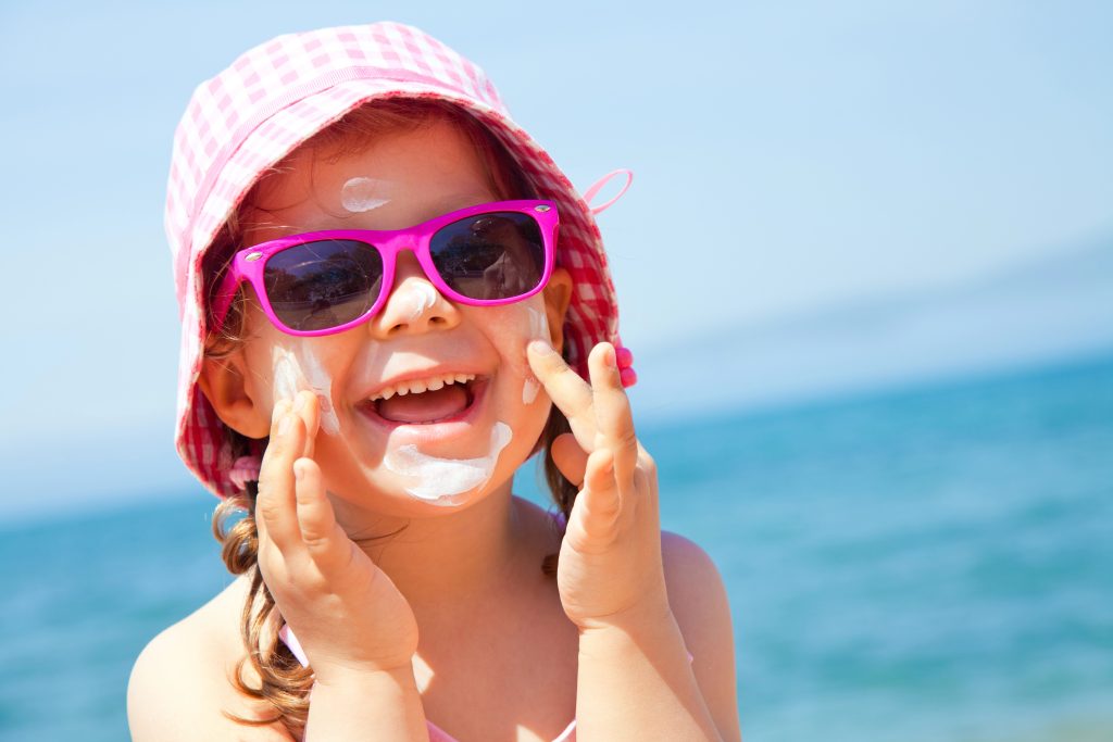 Child with bright healthy smile, enjoying summer at the beach.