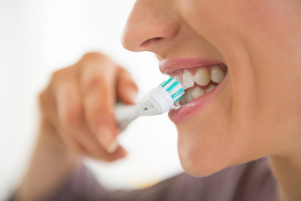 Close up of woman brushing her teeth. 